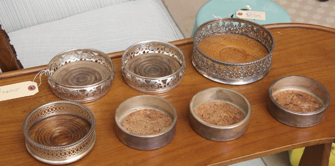 (7) Sheffield type silver plated wine coasters: (7) Sheffield type silver plated wine coasters, 20th c., incl. various size wine and bottle coasters, wood and cork base inserts, unsigned, largest: 6"dia.