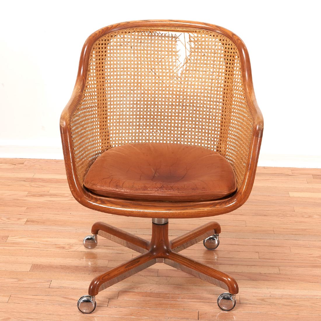 Ward Bennett desk chair: Ward Bennett desk chair, 1970s, American, caned bent ash frame on swivel base with casters, height adjustable, fixed saddle leather seat cushion, unsigned but for Brickell Associates, 34"h x 25"w x 19