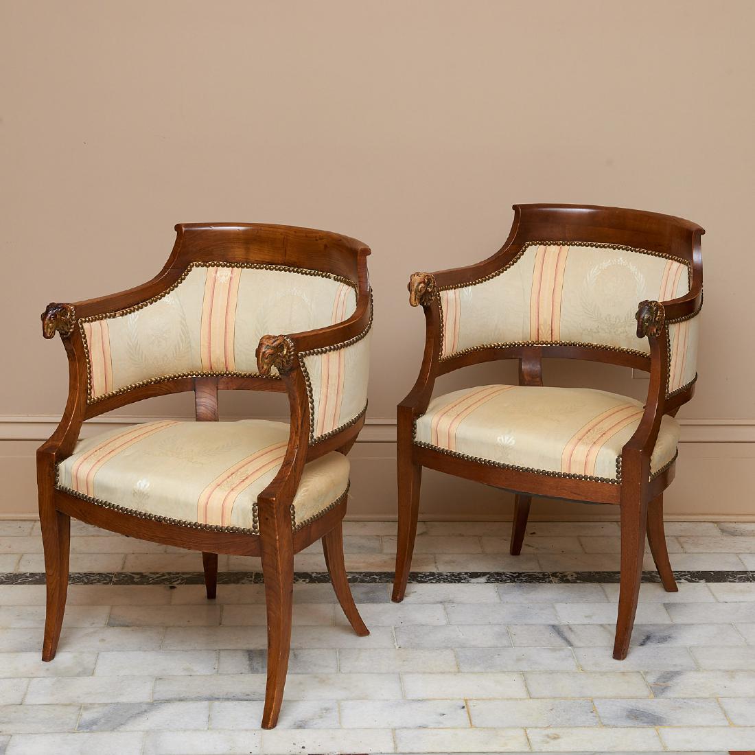 Pair fruitwood and parcel gilt bergeres: Pair fruitwood and parcel gilt bergeres, 19th c., Italy, arched arms ending in ram heads, tan/pink striped green silk upholstery, 35"h x 24"w x 21"d Provenance: Palmetto Hall: The Jay P. Altmayer Fami