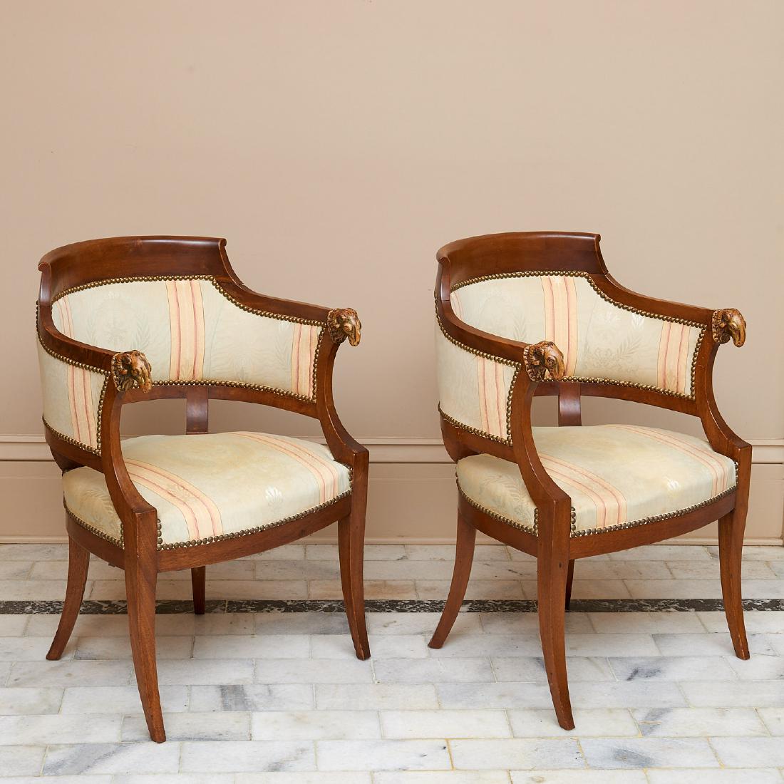 Pair fruitwood and parcel gilt bergeres: Pair fruitwood and parcel gilt bergeres, 19th c., Italy, arched arms ending in ram heads, tan/pink striped green silk upholstery, 35"h x 24"w x 21"d Provenance: Palmetto Hall: The Jay P. Altmayer Fami