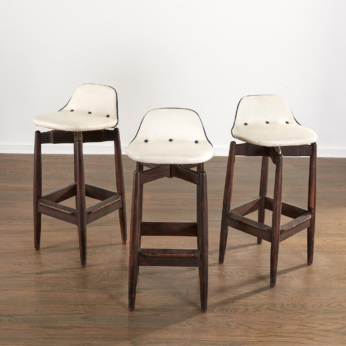 (3) Arne Vodder bar stools: (3) Arne Vodder bar stools, c. 1960, Denmark, teak frame with stretcher footrest, swivel vinyl upholstered seat, Sibast brand to underside, 36"h x 15"l x 15"w Provenance: From the Collection of Mr. an