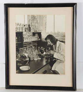 Gottscho - Schleisner, photograph: Gottscho - Schleisner, photograph, Samuel Gottscho (American, 1875-1971) and William Schleisner (American, 1912-1962), Woman looking through microscope, black & white photograph, signed lower right on