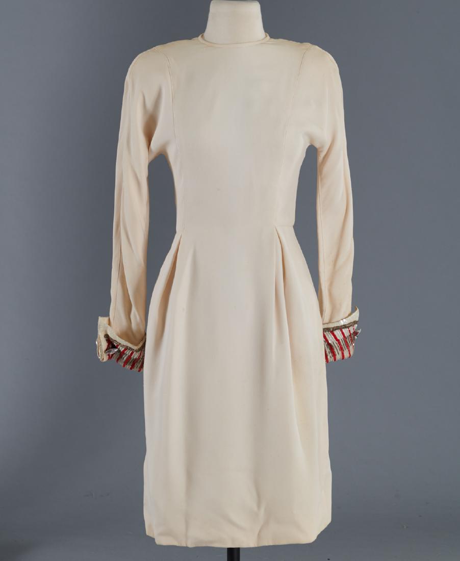 Custom sheath dress with embellished cuffs: Custom sheath dress with embellished cuffs, c. 1970's/1980's, ivory wool crepe, slim style with side slit pockets, pleating, zip back, snap foldover cuffs with beading and rhinestones, approx. 33.5"b,