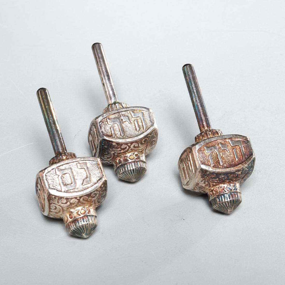 (3) Silver dreidels marked WH Hungary: (3) Silver dreidels marked WH Hungary, 19th/20th c., Continental, cast and chased sterling silver, each engraved in Hebrew on the stem, each stamped "WH Hungary 925", each 2.5"l, approx. 5ozt (total) 