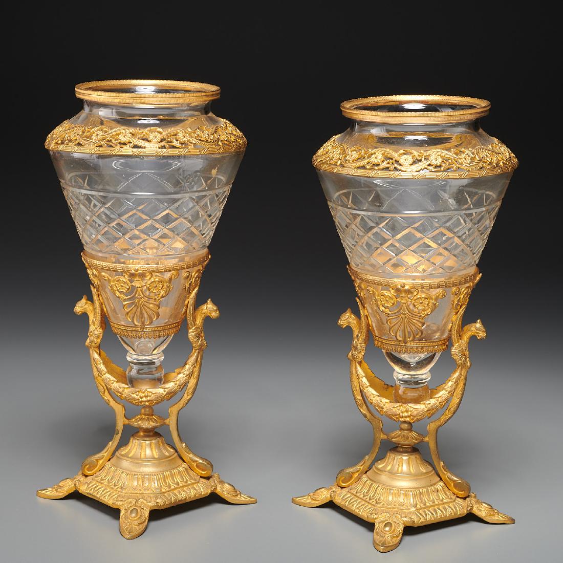 Pair Napoleon III gilt bronze, cut glass vases: Pair Napoleon III gilt bronze, cut glass vases, 19th c., bronze mounted conical amphoras resting in gilt cast bronze stands with gryphon-topped legs and laurel swags, 10"h x 5"dia Provenance: The Esta