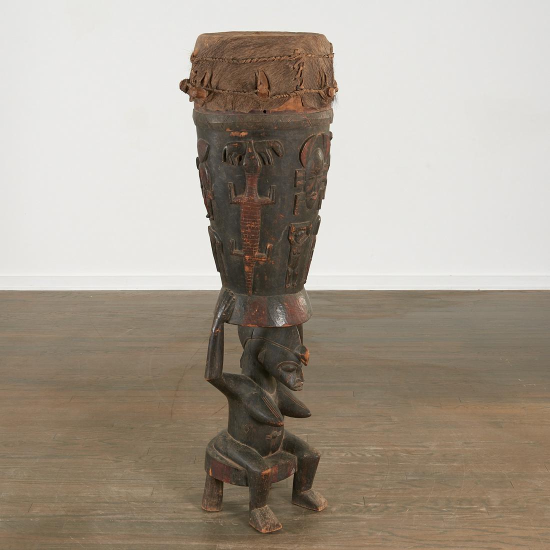 Senufo People, large figural ceremonial drum: Senufo People, large figural ceremonial drum, Mid-20th or earlier, Ivory Coast, wood and hide, carved in the form of a seated nude woman supporting a drum on her head, the drum decorated in the round 