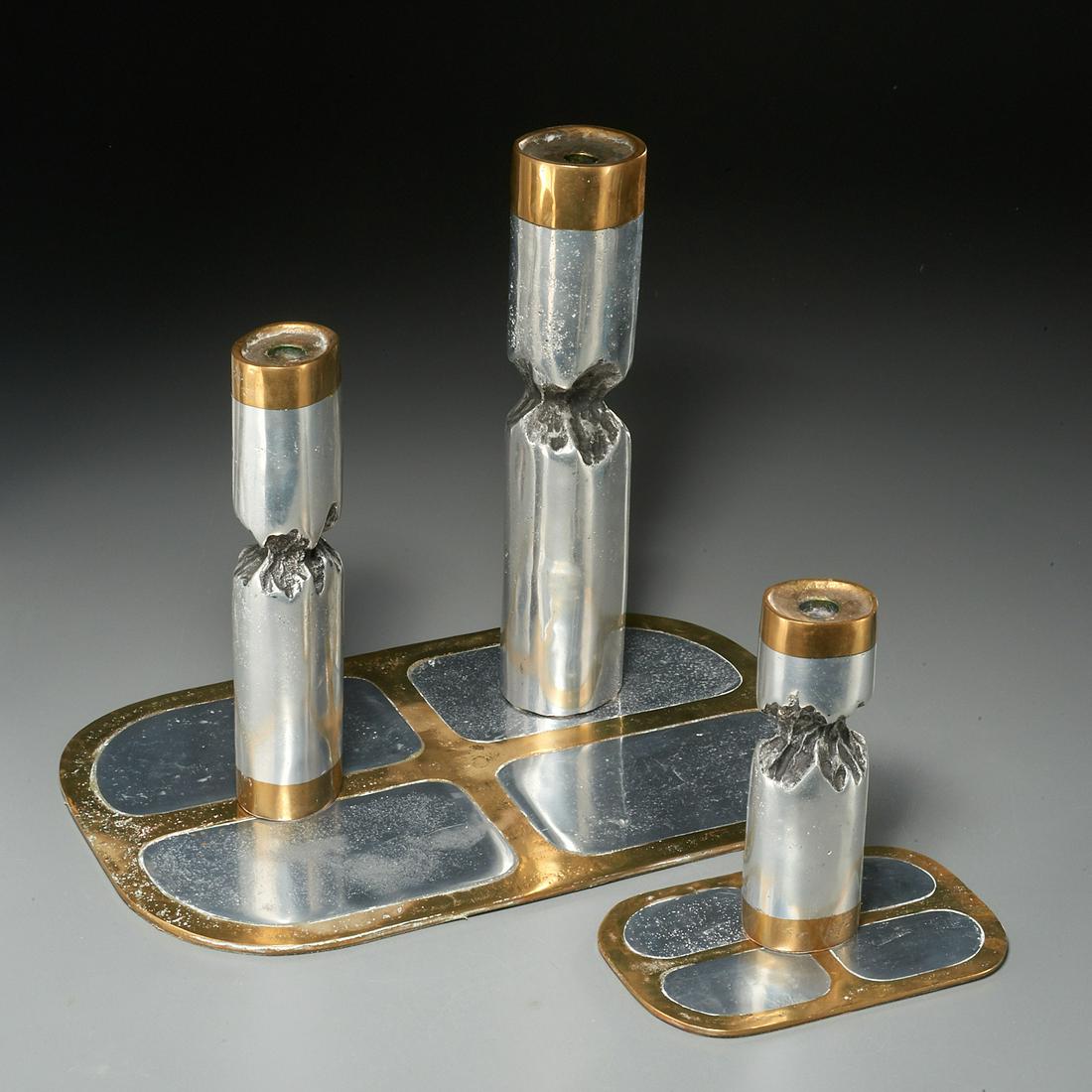 David Marshall, (5) piece tabletop group: David Marshall, (5) piece tabletop group, 1970s, Spain, cast aluminum and brass, including (3) tiered brutalist style candlesticks, (1) placemat, and (1) coaster, the candlesticks impressed with maker