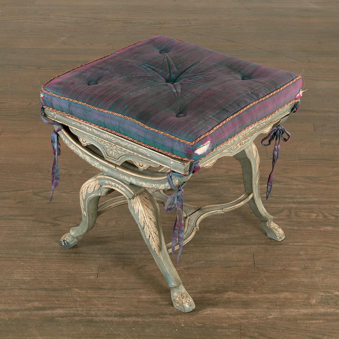 Continental painted curule tabouret: Continental painted curule tabouret, 19th c., carved and painted wood, cane seat, iridescent blue-green Thai silk seat cushion, decorated en grisaille with acanthus leaves and flower sprays, 19"h x 18