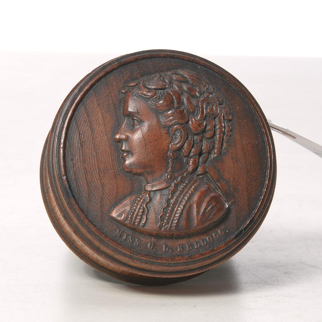 Clara Louise Kellogg treen snuff box: Clara Louise Kellogg treen snuff box, 19th c., American, carved in low relief with profile bust "Miss C.L. Kellogg", renowned opera singer, carved on underside "7/7", 1"h x 2.5"dia