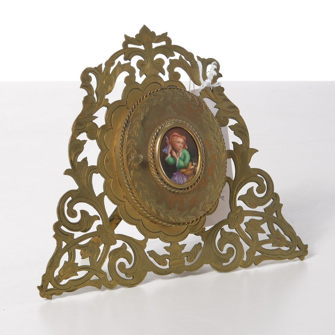 Antique easel frame with painted portrait plaque: Antique easel frame with painted portrait plaque, 19th c., English, pierced and engraved frame with hinged door inset with hand-painted portrait of a lady with dog, opening to locket style oval pictur