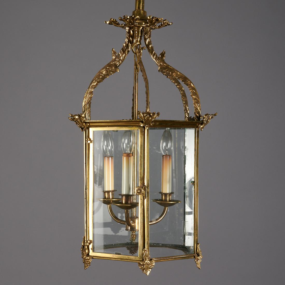 George III Brass Hexagonal Hall Lantern: George III Brass Hexagonal Hall Lantern, 19th c. and later, of typical form with acanthus scrolls and enclosing a three-light fixture, 27" h x 12" dia Provenance: The Collection of Elizabeth "Betty" S