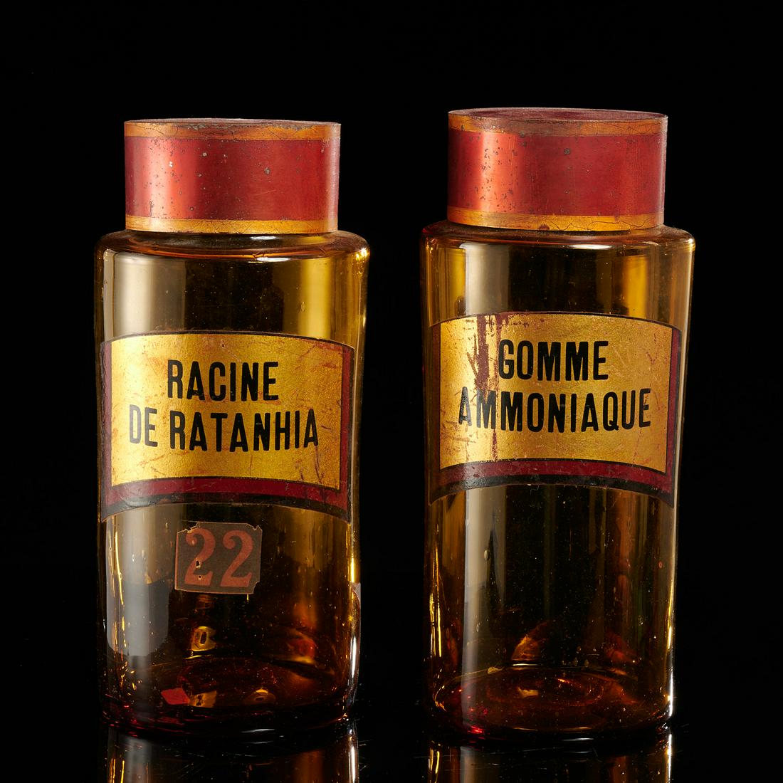 Pair antique amber glass apothecary jars: Pair antique amber glass apothecary jars, 19th c., probably French, blown-glass with tole lids, 10"h (with lids) x 4.25"dia
