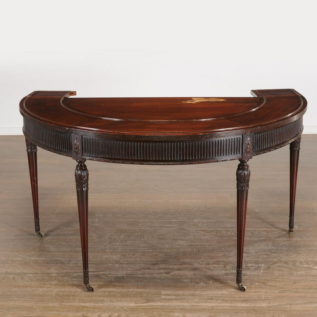 George IV carved mahogany wine table: George IV carved mahogany wine table, Early 19th c., England, the demi-lune top with reeded edge, rear drop-leaf panels, removable center sections, on tapering legs and brass casters, 30"h x 57"l x 29