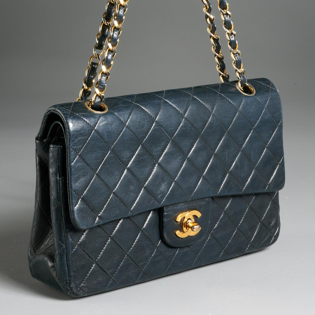 Chanel classic navy double flap quilted lambskin: Chanel classic navy double flap quilted lambskin, 20th c., medium size, front flap with gold toned "Double CC" lock, interior in burgundy with (3) sections, central with fitted pockets, double shoulde