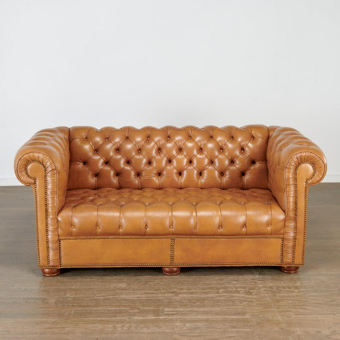 Nice quality leather chesterfield loveseat: Nice quality leather chesterfield loveseat, 20th c., possibly Smith & Watson, tufted light brown leather back and seat with scrolling edge, brass rivet trim, on walnut bun feet, 30"h x 67"l x 34"d, 16
