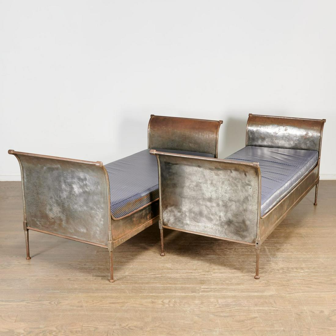Great pair antique French cold steel daybeds: Great pair antique French cold steel daybeds, 19th c., campaign furniture, of sleigh form with out-scrolling head and foot boards joined by shaped rails on round tapering legs, unmarked, 34"h x 31.5"w