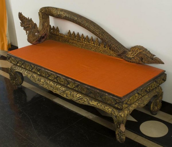 Antique Thai carved giltwood Naga dragon bench: Antique Thai carved giltwood Naga dragon bench, 19th/20th Century, possibly Burmese, the Naga dragon-form backrest over a rectangular seat on similarly carved legs, 32"h x 59.5"l x 23"d Provenance: Th