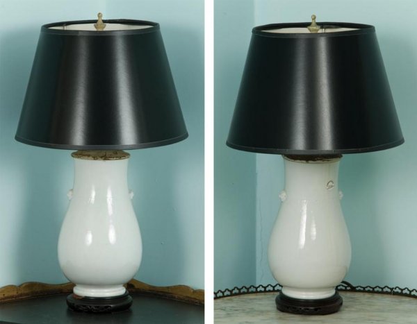 Pair antique Chinese white glazed vases: Pair antique Chinese white glazed vases, Qing Dynasty, mounted as lamps, of pear form with Buddhist lion mask handles and incised lappet decoration, hardwood stands, 9.75"h x 6"dia. (excluding fitting