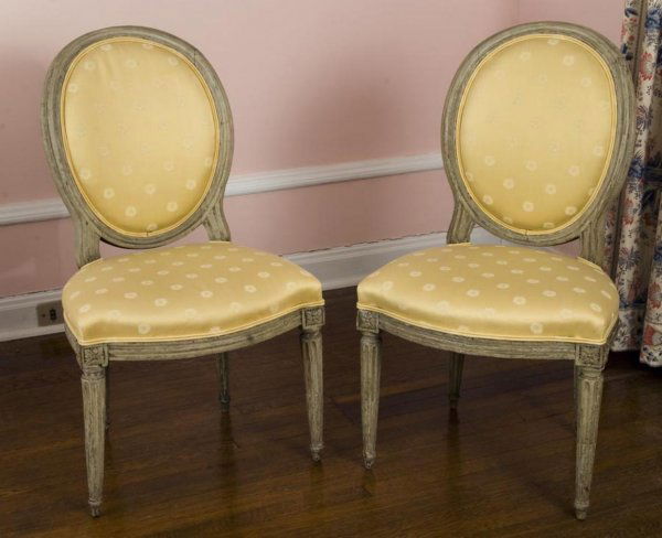 Pair Louis XVI gray painted chaises en gondole: Pair Louis XVI gray painted chaises en gondole, 18th/19th Century, the oval backrest and serpentine seat upholstered in a yellow-gold on round tapering fluted legs, 35"h x 20"w x 17"d Provenance: The