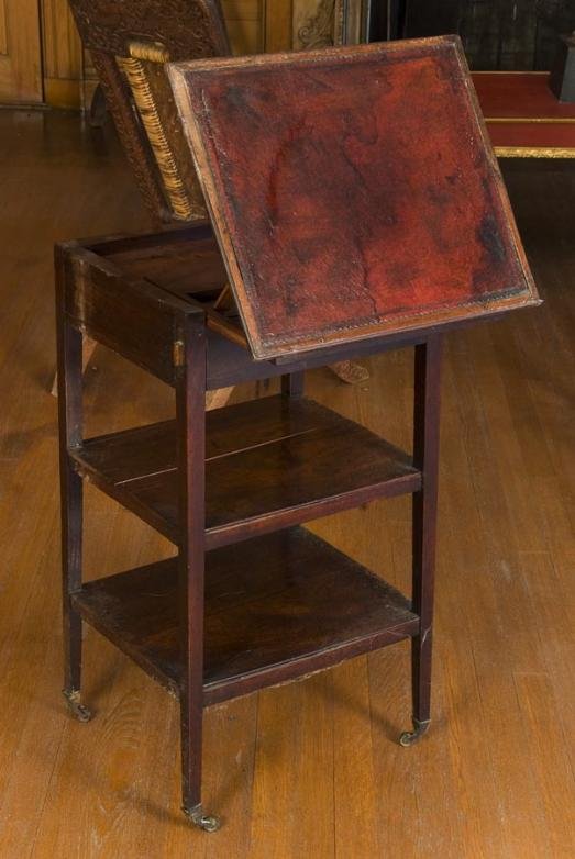 George III mahogany drafting table: George III mahogany drafting table, Late 18th Century, the rectangular leather inset top with tilting prop mechanism over a single drawer on square tapering legs joined by shelves, 30"h x 14"w x 17"d 