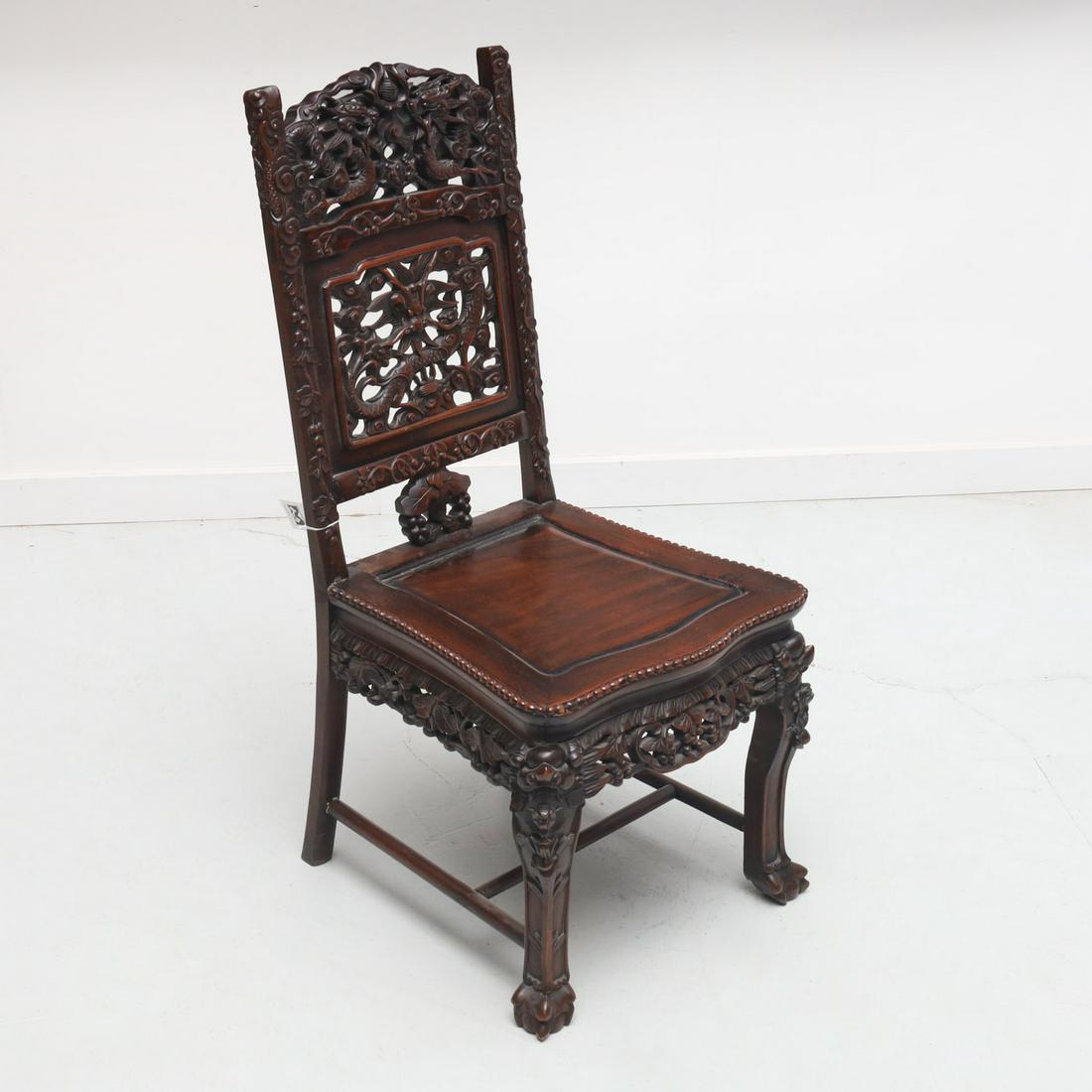 Chinese Export carved hardwood dragon chair: Chinese Export carved hardwood dragon chair, 19th/20th c., intricately carved pierced double dragon design, with cherry blossoms, and foliage, unmarked, 38.5"h x 17.75"w x 18.25"d