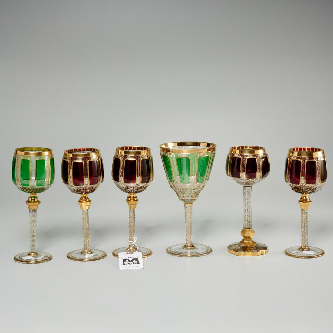 (6) Moser (attrib) Bohemian glass wine goblets: (6) Moser (attrib) Bohemian glass wine goblets, 20th c., incl. (4) ruby and (2) green paneled wine glasses, of varying forms, each with gilt decoration, banding, and knopped stem, unmarked, 7.75"h x 4