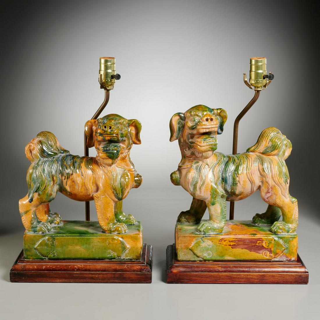 Pair Chinese sancai foo dogs mounted as lamps: Pair Chinese sancai foo dogs mounted as lamps, 19th/20th c. and adapted, China, polychrome glazed earthenware, book matched dogs standing foursquare on a rectangular plinth, raised on a wood base issu