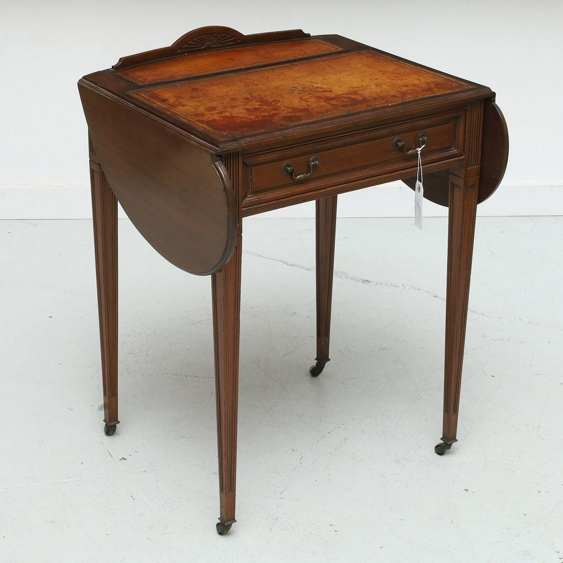 Edwardian writing table by James Craig & Co.: Edwardian writing table by James Craig & Co., Late 19th/20th c., Glasgow, of unusual form with double drop leaves, tooled leather writing surface, and fitted writing compartment on tapering legs and c