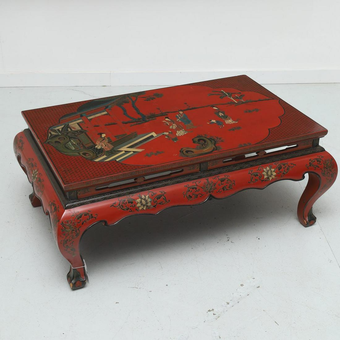 Chinese style red lacquered coffee table: Chinese style red lacquered coffee table, 20th c., figures in a garden scene to tabletop, shaped apron, unmarked, 17.75"h x 43.75"l x 27.5"d