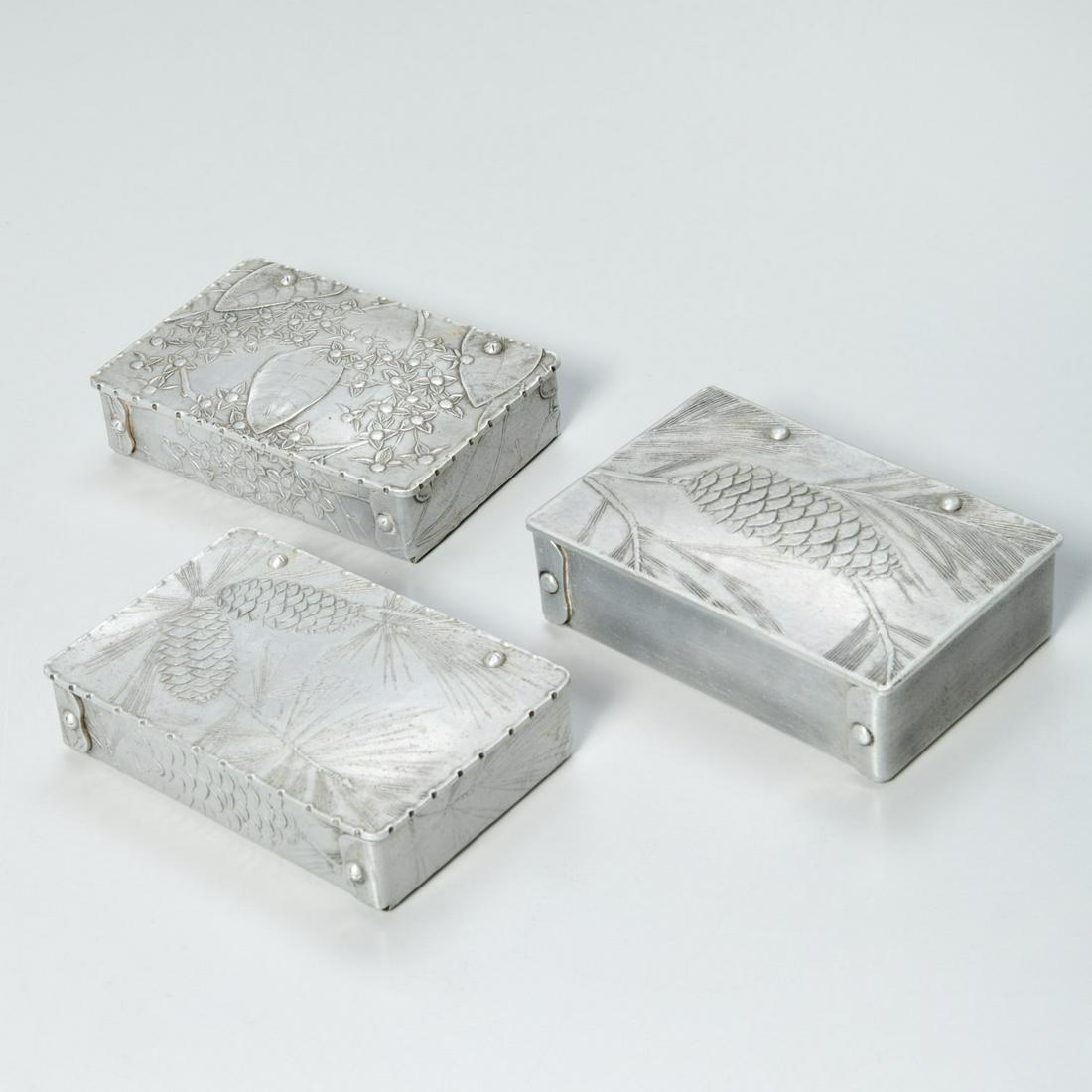 Wendell August Forge aluminum cigarette boxes: Wendell August Forge aluminum cigarette boxes, Mid 20th c., American, forged aluminum boxes with low relief flowering branch and pinecone designs, one with divided interior, each with maker's stamp, 1