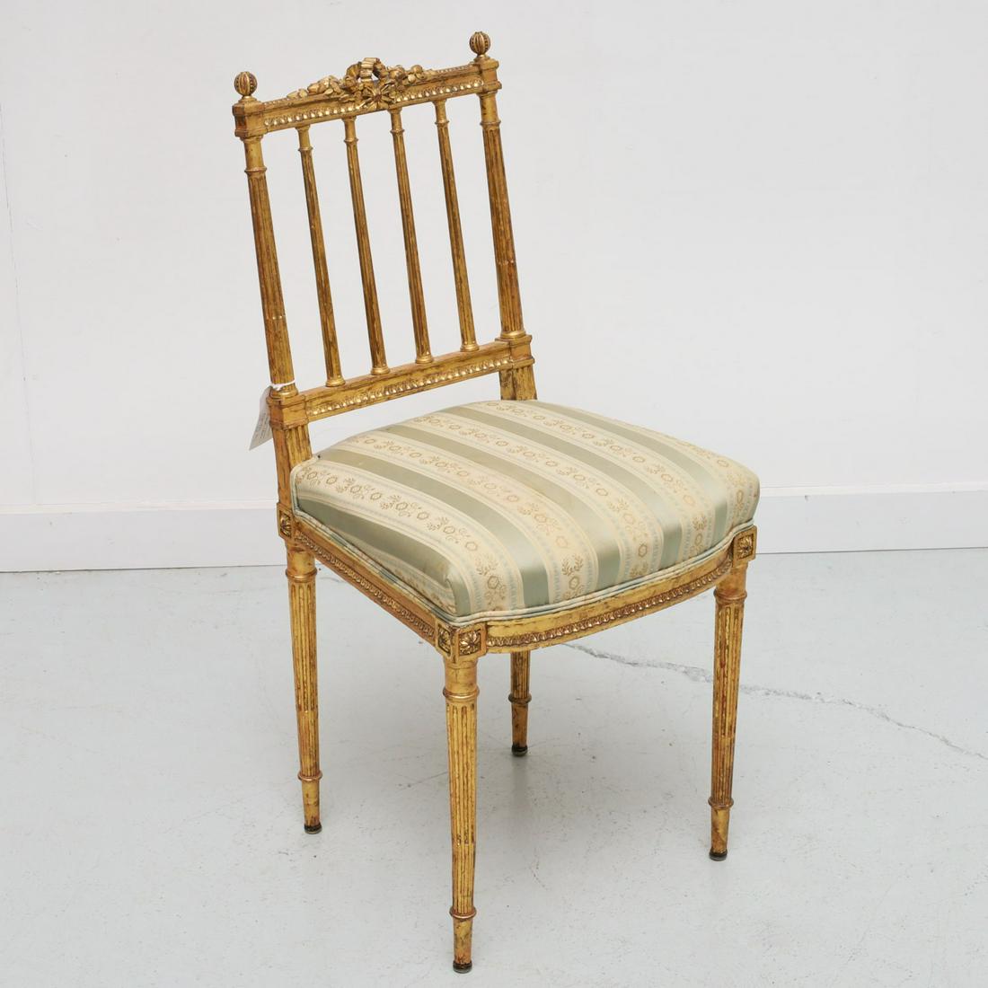 Louis XVI style petit giltwood side chair: Louis XVI style petit giltwood side chair, 19th c., carved and gilt wood chair, with fluted columnar back, ribbon and floral crest, on tapering fluted legs, damask upholstered seat, 33.25"h x 15.5"w x