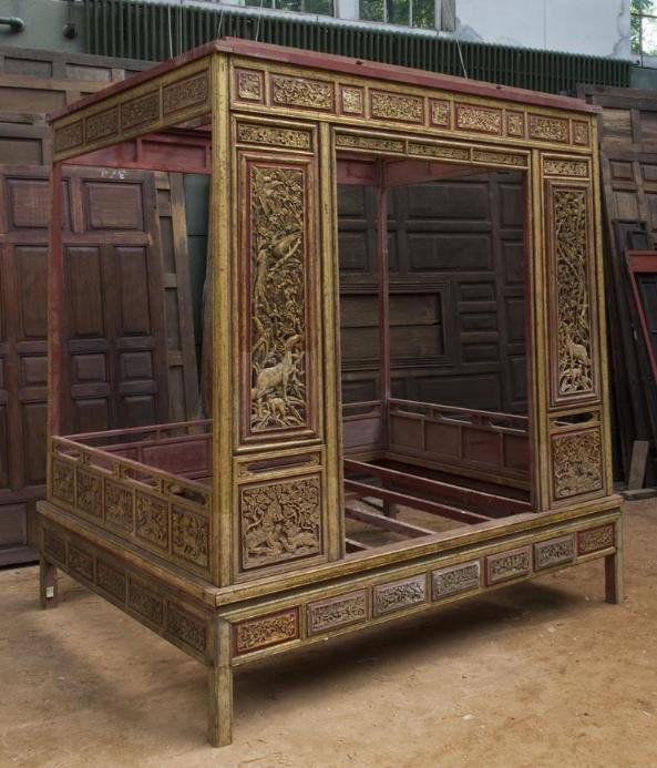 Antique Thai carved giltwood and red lacquered Chin: Antique Thai carved giltwood and red lacquered Chinese bed, 19th/20th century, the canopied sleeping platform set with decorative blind and pierced panels depicting foliage, animals and Buddhist lions