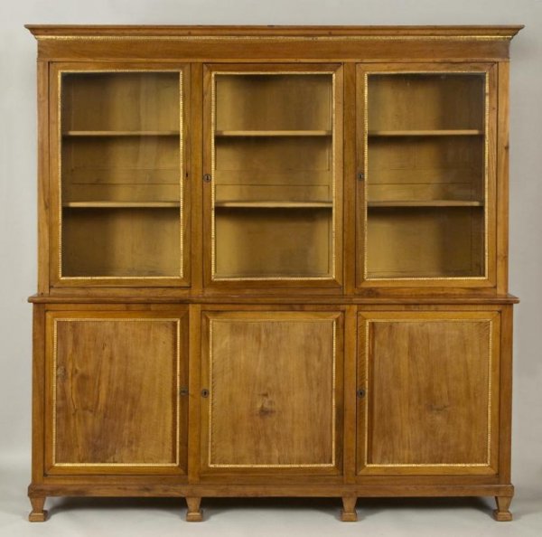 Italian Neo-classical parcel gilt walnut bookcase : Italian Neo-classical parcel gilt walnut bookcase cabinet, Late 19th century, the upper section with molded cornice over 3 glazed panel doors, the base with work slide and 3 cupboard doors on square t