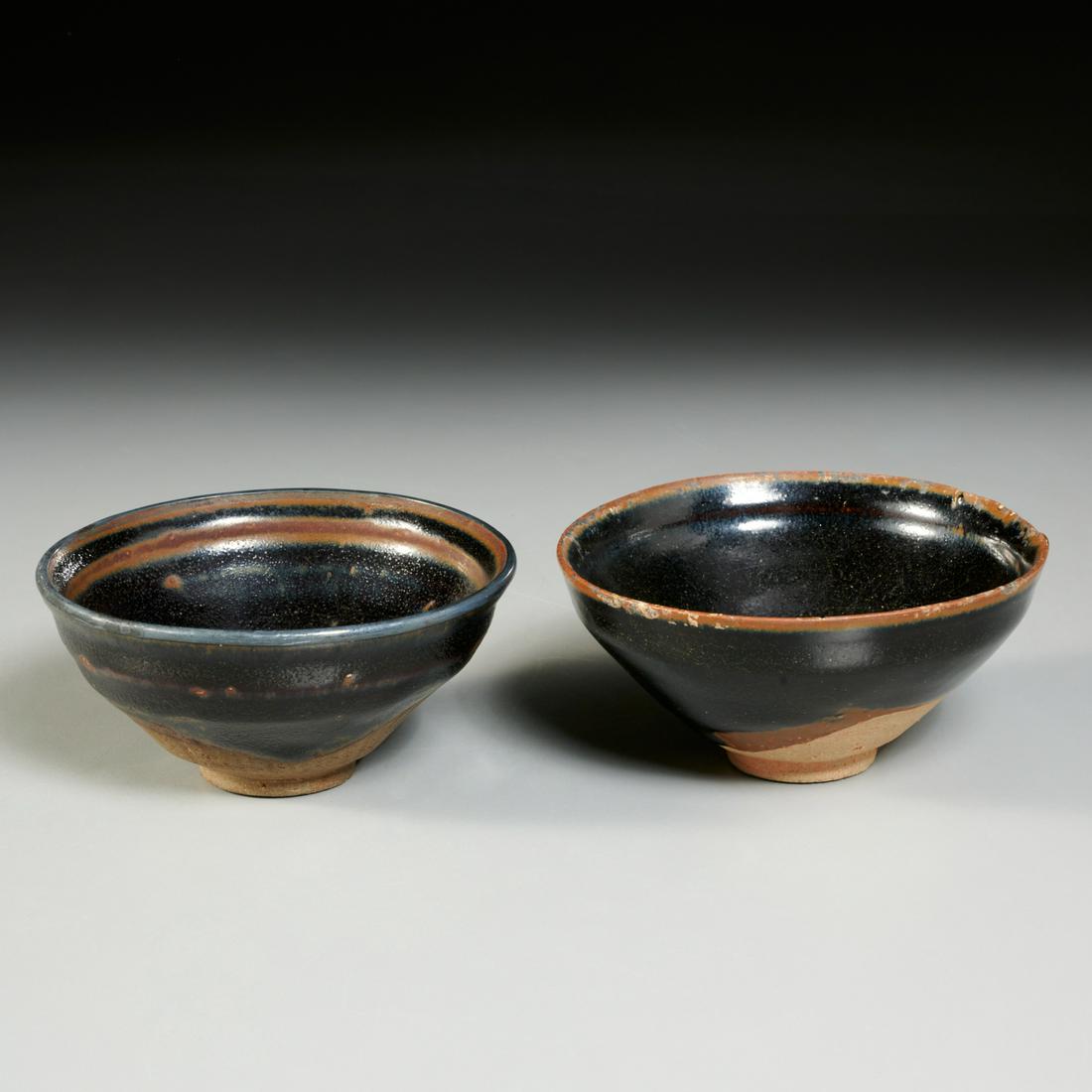(2) Chinese Jian Temmoku glazed bowls: (2) Chinese Jian Temmoku glazed bowls, Song Dynasty or later (post 960 ACE), russet and black glazed stoneware, the underside and round foot unglazed, one in a light red clay, the other a darker brown