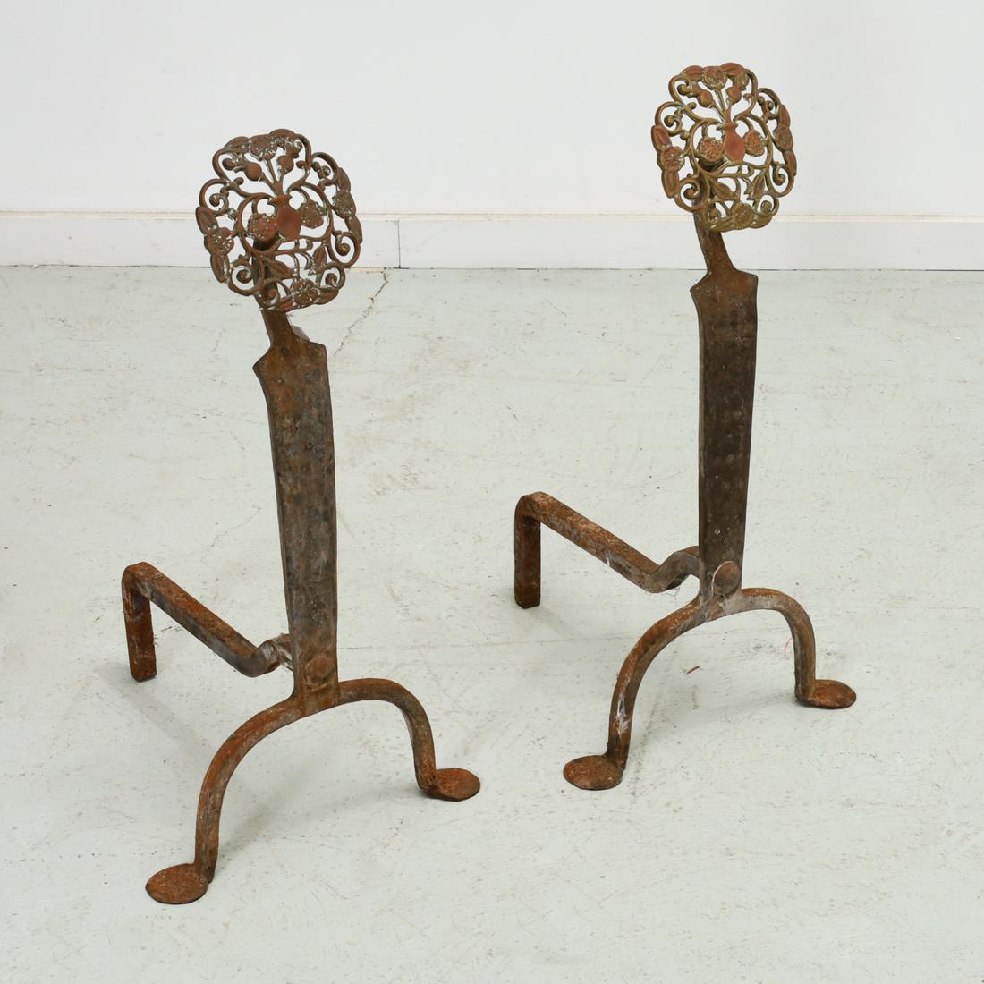 Pair Arts & Crafts brass and iron andirons: Pair Arts & Crafts brass and iron andirons, First half 20th c., in the manner of Ernest Gimson, each hand hammered upright topped with a pierced openwork brass floral scroll medallion, unmarked, 25"h