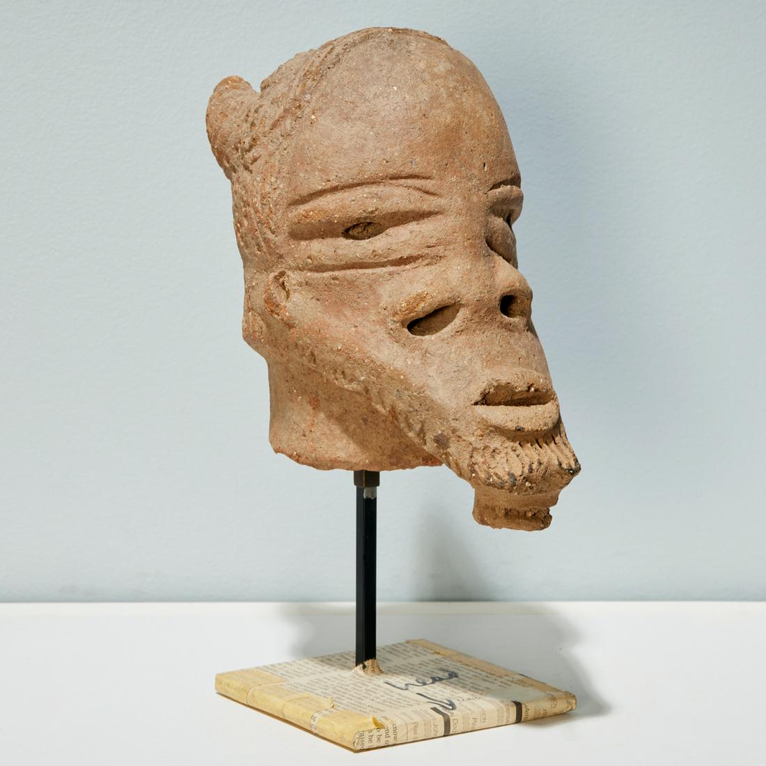Katsina Culture, terracotta head: Katsina Culture, terracotta head, Possibly 200 BCE-100CE, Nigeria, hand-moulded with incised features and coiffure and beard, on custom metal stand, 9"h (head) Provenance: Estate of Distinguished Prof