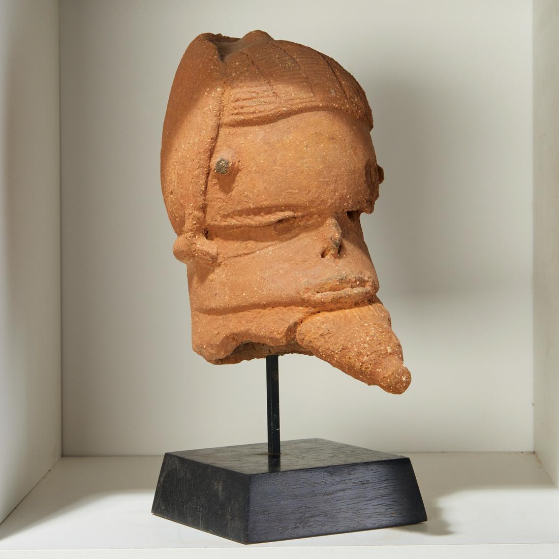Katsina Culture, terracotta head: Katsina Culture, terracotta head, Possibly 200 BCE-100 CE, modern Nigeria, hand-moulded with incised features and coiffure and beard, on custom stand, 7"h x 5"w x 7"d (head) Provenance: Estate of Dist