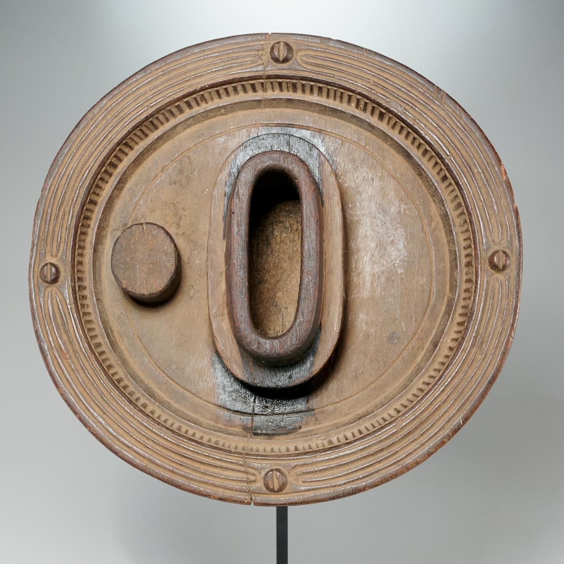 Igbo Peoples, Okwa Kola nut bowl: Igbo Peoples, Okwa Kola nut bowl, Nigeria, carved wood, oval center receptacle on shallow dish with wide rim, channel banding, attached to custom metal stand, 15"dia Provenance: Estate of Distinguishe