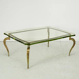 Maison Ramsay (attrib.), brass cocktail table: Maison Ramsay (attrib.), brass cocktail table, c. 1960, with one-inch thick shaped glass top, the stylized scrolling legs attached to frame with large decorative screw heads, unsigned, 17"h x 42"l x 3