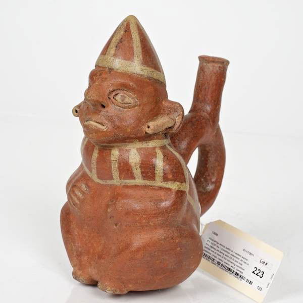 Vicus effigy stirrup bottle of a seated warrior: Vicus effigy stirrup bottle of a seated warrior, 8"h x 6.25"dia. Provenance: From an important and internationally renowned single owner collection sold anonymously without reserve.