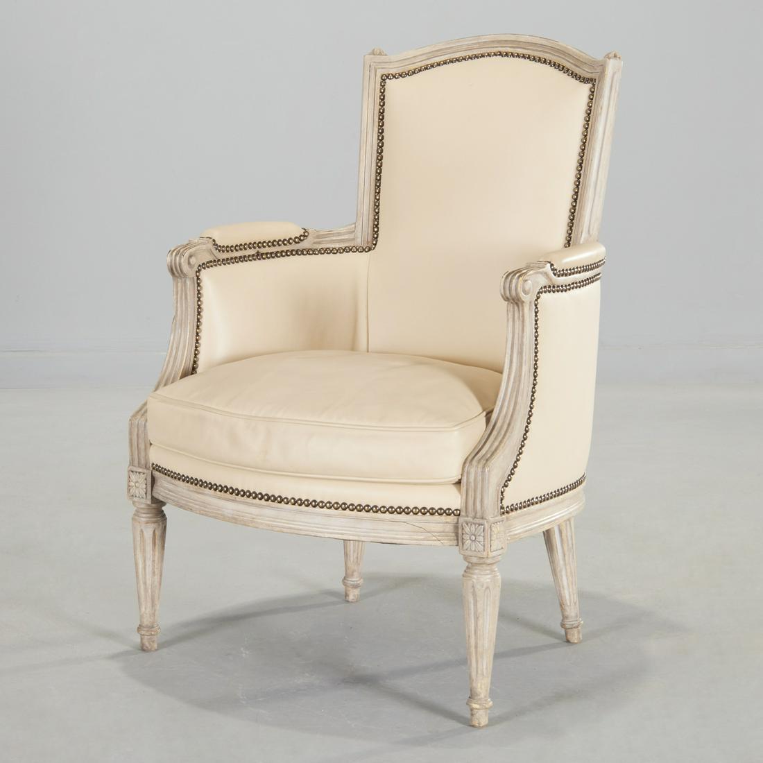 Louis XVI style grey painted and leather bergere: Louis XVI style grey painted and leather bergere, 19th/20th c., France, channel carved frame of barrel form, with arched crest rail, inward curving padded arms, with round fluted tapering feet, the bo