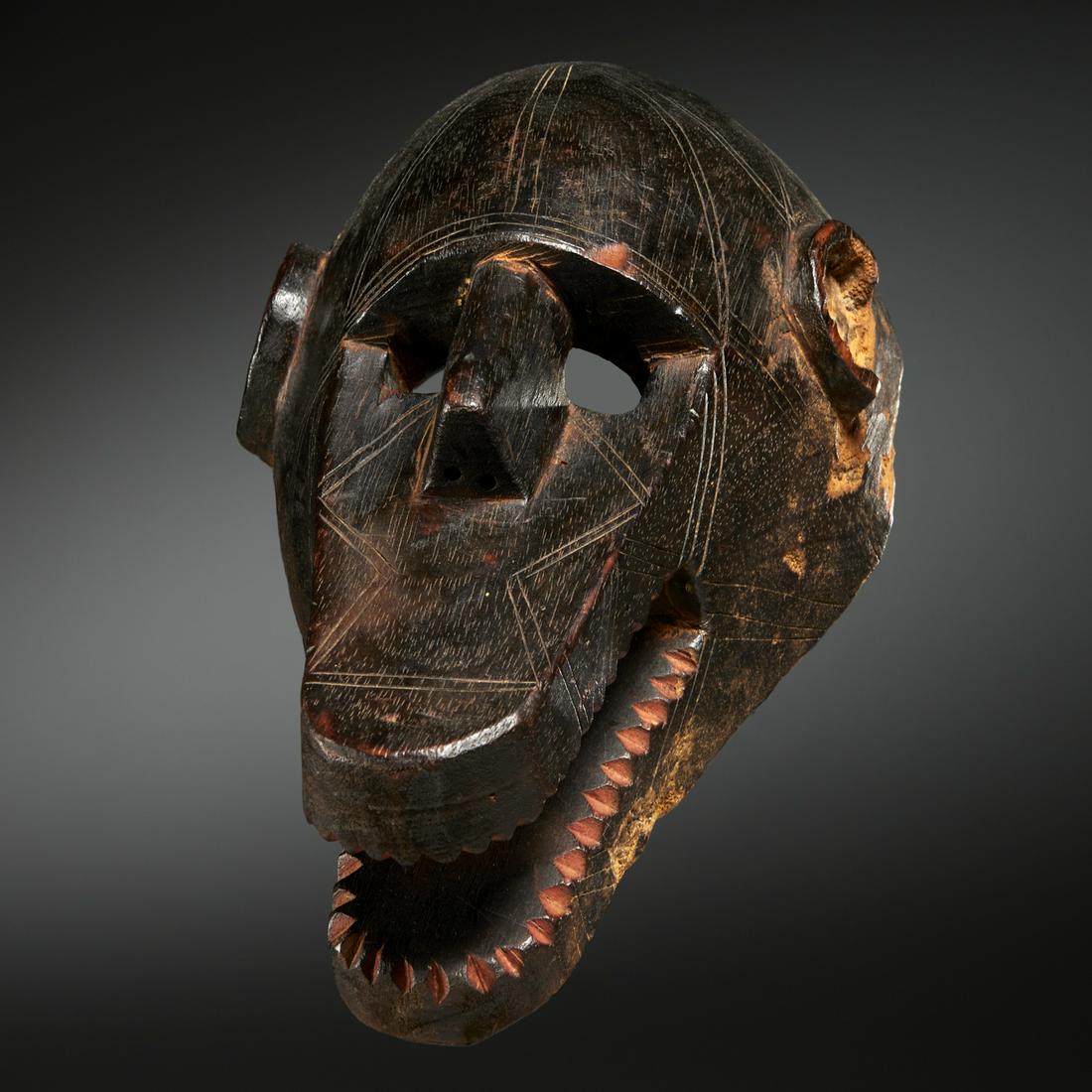 Bamana Peoples N'go, Koun monkey mask: Bamana Peoples N'go, Koun monkey mask, 20th c., Mali, dark patina wood with red pigment, stylized with U-shaped ears, flat bill-form open mouth with saw teeth, incised with geometric banding, old exhi