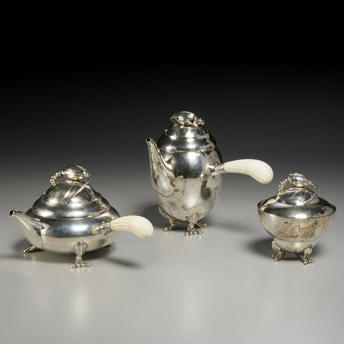 Georg Jensen, early production Blossom tea set: Georg Jensen, early production Blossom tea set, dated 1918, Denmark, hand-hammered .830 silver, carved bone handles, including coffee pot with flower-topped domed lid, 9"h x 9"l x 6"w, tea pot, 5"h x