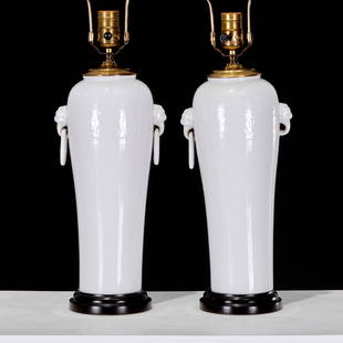 Pair Chinese blanc de chine vase lamps: Pair Chinese blanc de chine vase lamps, 20th c., white glazed porcelain, the round tapering body incised with a floral band, foo lion and ring handles, mounted with wood base and brass lid topped