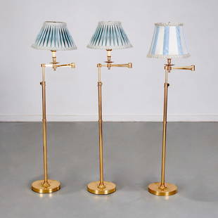 (3) Classic brass swing arm floor lamps: (3) Classic brass swing arm floor lamps, 20th/21st c., adjustable height, approx. 55"h x 11"w x 9.25"d (arm closed), 19"w (arm extended), 8.5"h x 13.75"dia (pair shades), 10"h x 12.5"dia (single shade