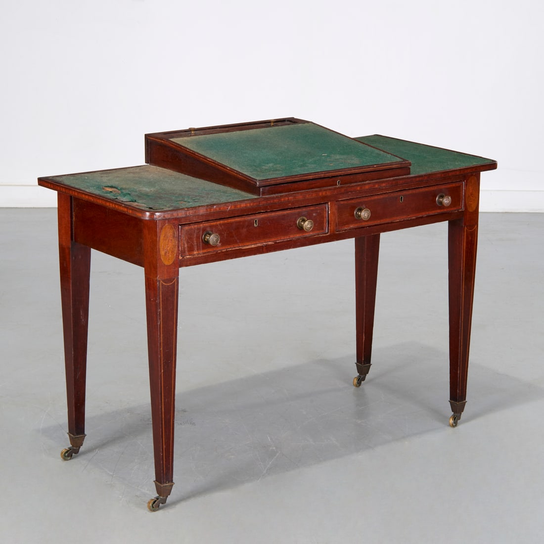 Federal mahogany slant front writing desk: Federal mahogany slant front writing desk, 19th c., USA, green felt lined top with central hinged writing surface, opening to storage and inkwell, on square tapering legs ending in brass casters, 31"h