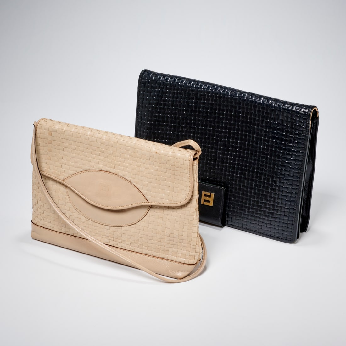 (2) Fendi woven handbags: (2) Fendi woven handbags, 20th c., Made in Italy, (1) ivory flap clutch with removable shoulder strap, embossed double F to center medallion, interior in logo F fabric, makers nameplate, single zipper