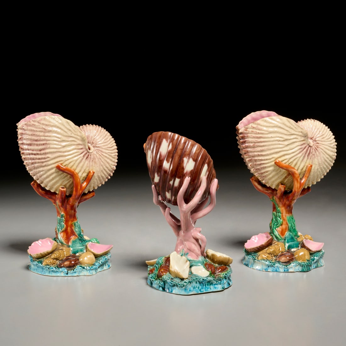 Royal Worcester majolica nautilus shell garniture: Royal Worcester majolica nautilus shell garniture, Late 19th c., England, polychrome tin glazed earthenware, (3) pieces, each modeled as shells surmounting a coral stump and shell-strewn rocky base, i