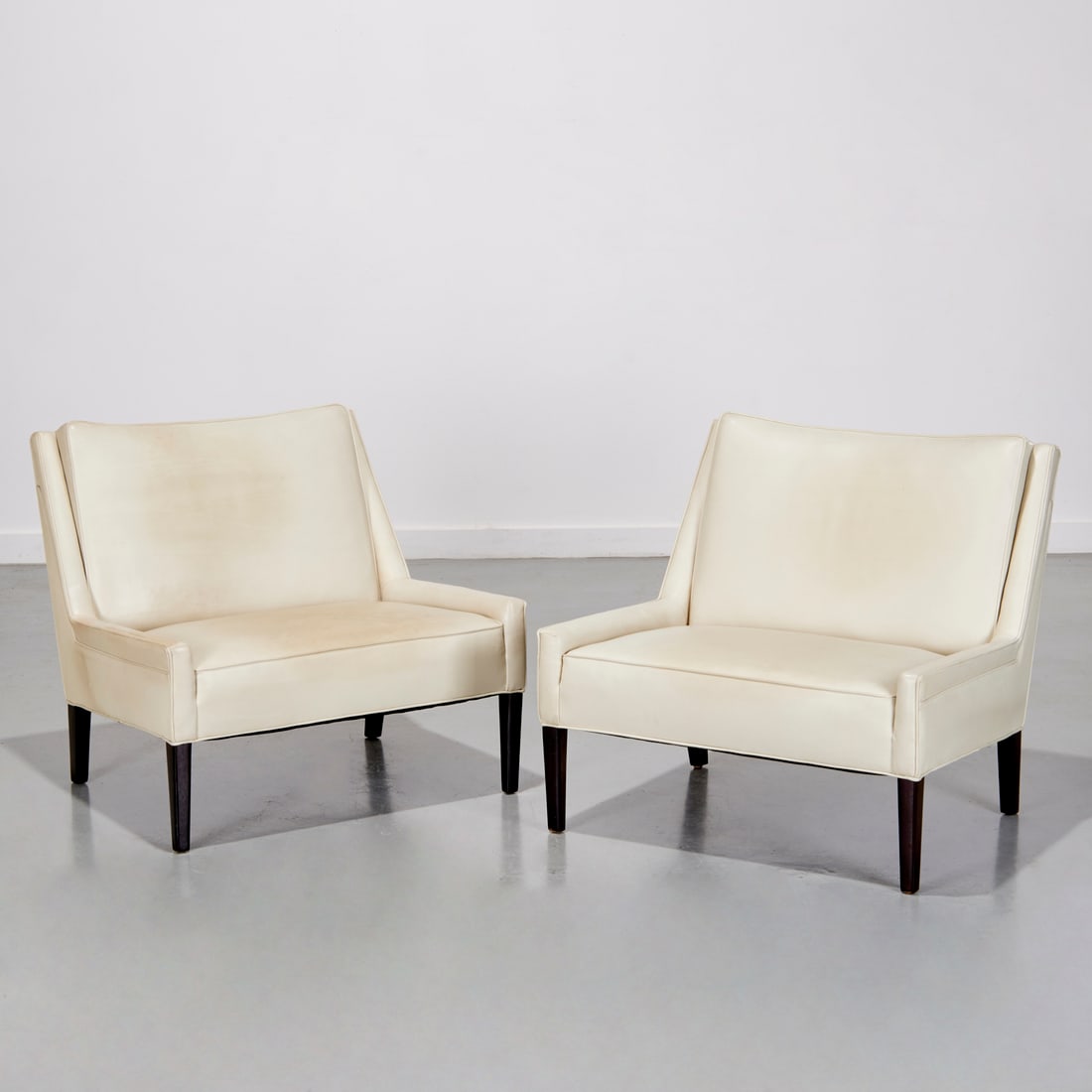 Annabelle Selldorf (attrib), leather lounge chairs: Annabelle Selldorf (attrib), leather lounge chairs, 20th/21st c., possibly French, tight off-white leather seat and back, raised on dark stained wood legs, 29"h x 31"w x 30"d, 15"h (to seat) Provenanc