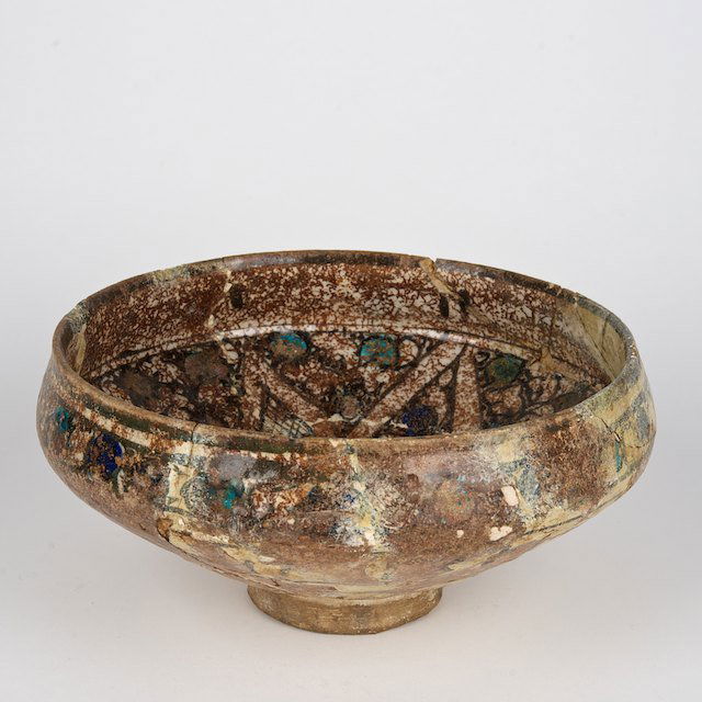 Antique Islamic glazed pottery bowl: Antique Islamic glazed pottery bowl: Prob. 12th/13th c., prob. Kashan, interlocking band design with blue dots, 4"h x 8.25"dia. - Condition Report: overall poor, extensive restorations, glaze loss, cr